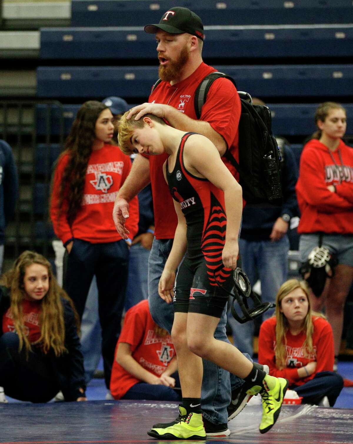 FILE - In this Feb. 18, 2017, file photo, Euless Trinity's Mack Beggs is consoled by coach Travis Clark after Beggs' opponent forfeited during the finals of the UIL Region 2-6A wrestling tournament at Allen High School in Allen, Texas. When Texas transgender wrestler Mack Beggs won a girlsÂ?’ state championship, his victory drew jeers and complaints that his steroid therapy treatment had given him an unfair advantage against girls who risked injury just by getting on the mat with him, Now state lawmakers are pushing a bill that could deny Beggs, a Dallas area-junior, a chance to defend his title. (Nathan Hunsinger/The Dallas Morning News via AP, File)