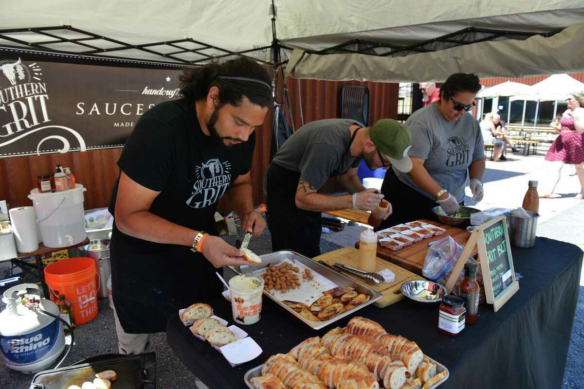 Michael Grimes (center), and Elisa Trevino (right) prepare Southern Grit BLT's during a pop-up dining event.