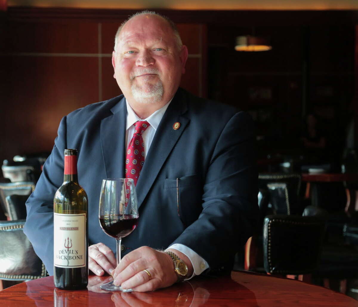 Master Sommelier Guy Stout with a bottle of Devil's Backbone a red blend wine at Sullivan's Restaurant in Houston.