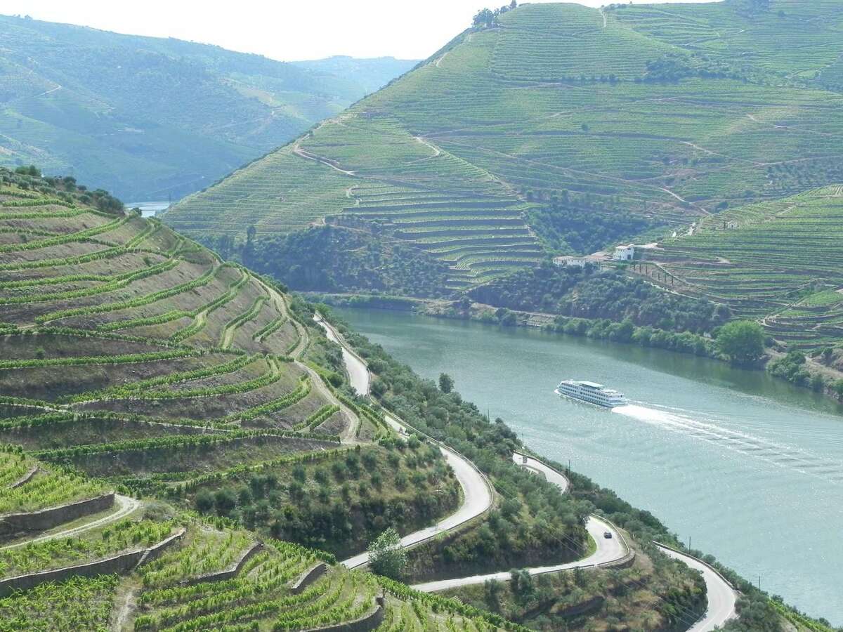 As longboats cruise westward from Porto, the city’s urban scene quickly changes to steep mountains draped with vineyards.