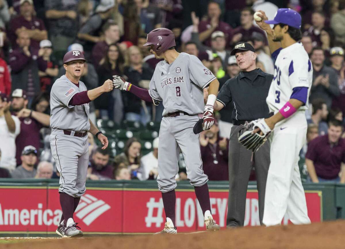 Texas A&M second basemen Braden Shewmake (center) gets a fist bump after reaching third on a triple against TCU at Minute Maid Park on March 4, 2017, in Houston.