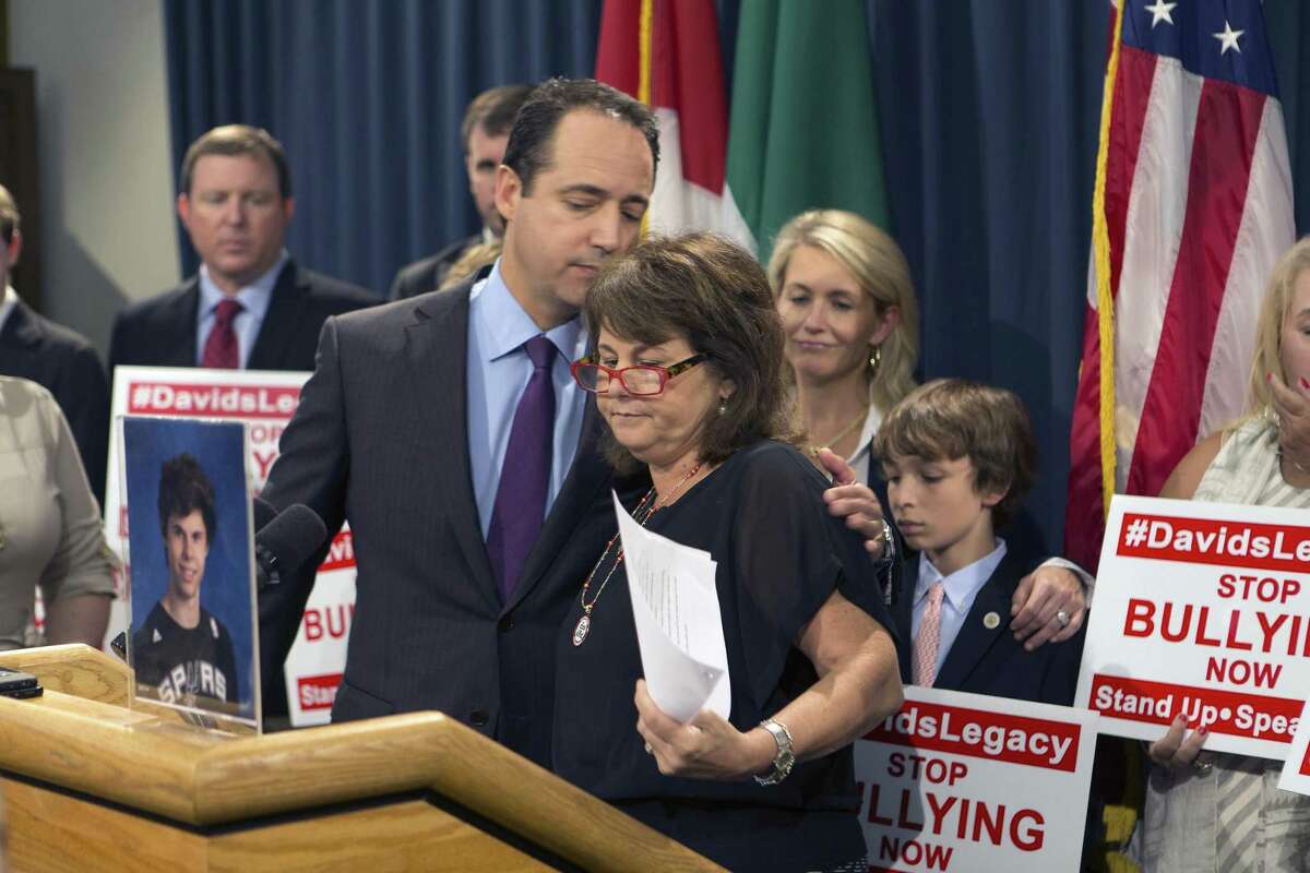 State Sen. Jose Menendez, left, hugs Maurine Molak after she spoke Tuesday, Aug. 23, 2016 at a press conference at the Capitol about a bill being sponsored in her son, David Molak's name. David Molak committed suicide after being cyberbullies by other teenagers. The bill would close gaps in current laws that make it hard to prosecute cyberbullies.