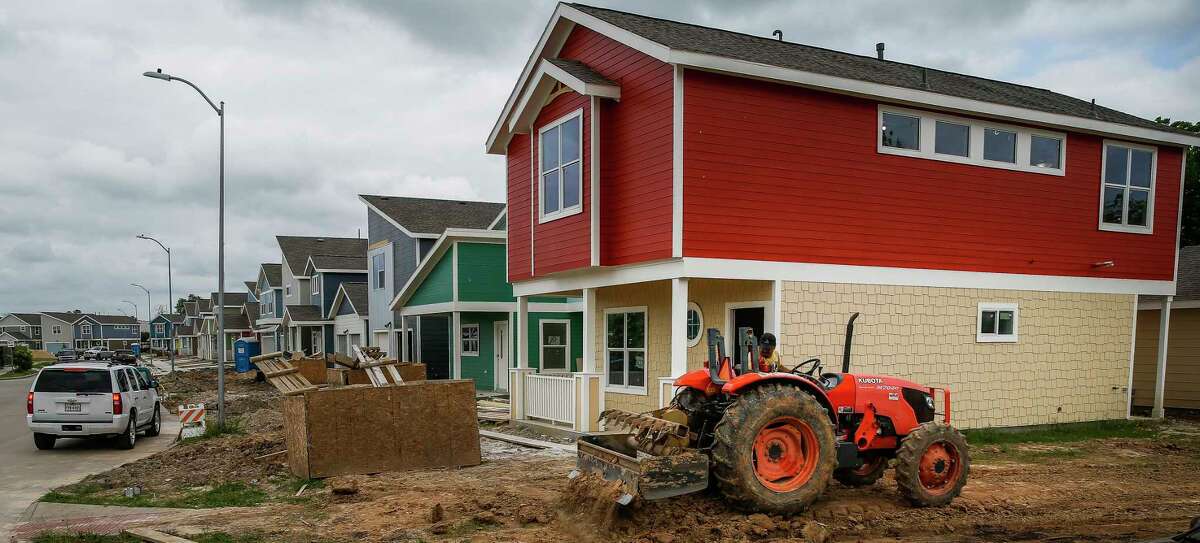 A tractor moves dirt around a home under construction in the Avenue Place affordable housing neighborhood Tuesday, April 25, 2017 in Houston. Click through the gallery to see what you need to earn to buy a house in Houston. 