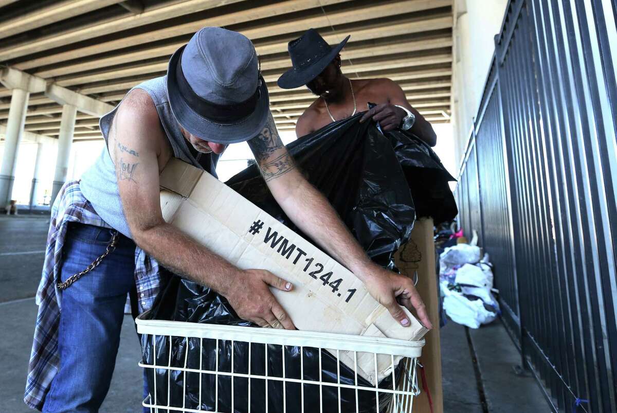 Edwin Ford, right, and Roy Dailey are packing up their belongings into a small cart ﻿in preparation for moving from underneath the overpass of U.S. 59 at Congress Ave. Friday. ﻿