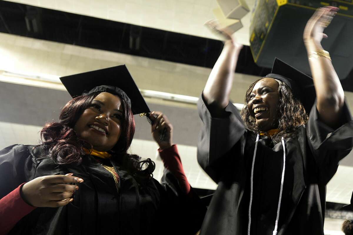 From left, Rehema Chambuso and Glyndia Charles move their tassles and celebrate during the Midland College commencement ceremony May 12, 2017, at Chaparral Center. James Durbin/Reporter-Telegram