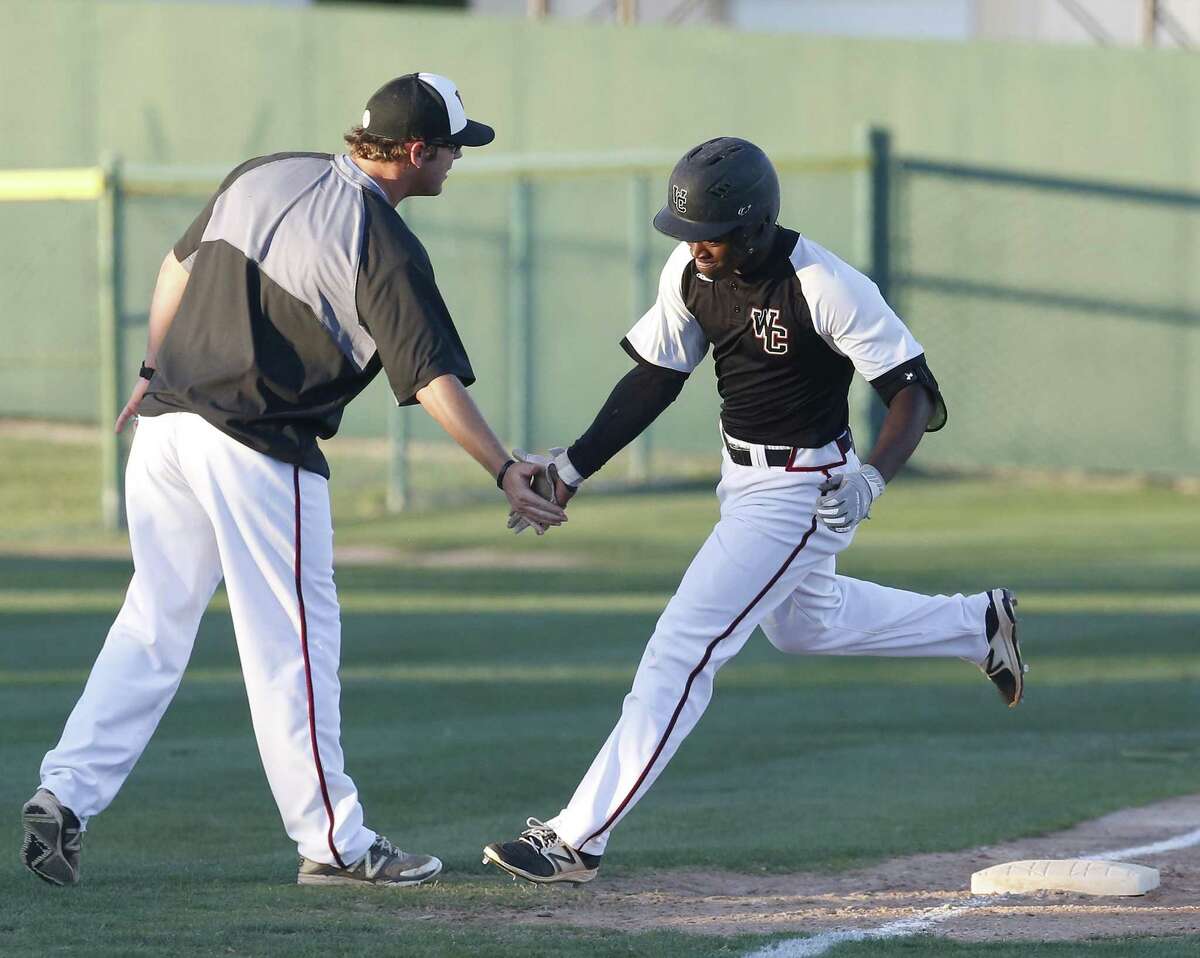 Churchill’s Jordan Billups rounds third base after hitting a third-inning home run against Clemens and is congratulated by Chargers coach Alan Hill (left) on May 12, 2017. Churchill defeated Clemens, 6-2, to advance in the Class 6A playoffs.