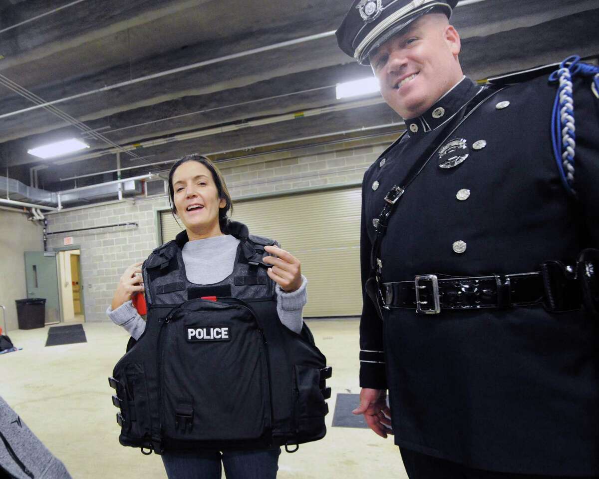 Natalie Stein of Greenwich, left, got to try on a police vest with the help of Greenwich Police Officer Thomas Huestis during the Greenwich Police Department's fifth annual Police Day at the Greenwich Public Safety Complex in Greenwich, Conn., Saturday, May 13, 2017. The public was given a hands-on opportunity to interact with the police in an event that featured a police motorcycle, the Greenwich Police K-9 Kato, a SWAT vehicle, scuba gear from the Police Marine unit as well as uniformed officers from the various departments of the Greenwich Police. The event was done in conjunction with the Junior League of Greenwich.