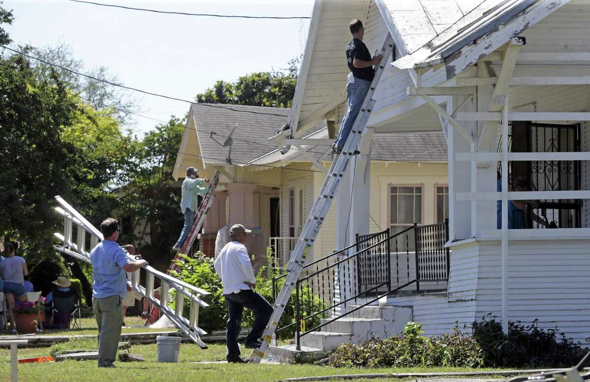 Teams bring in ladders to reach high on the home exteriors during Rehabarama, a project to revitalize homes on two blocks of Harding place on May 13, 2017.