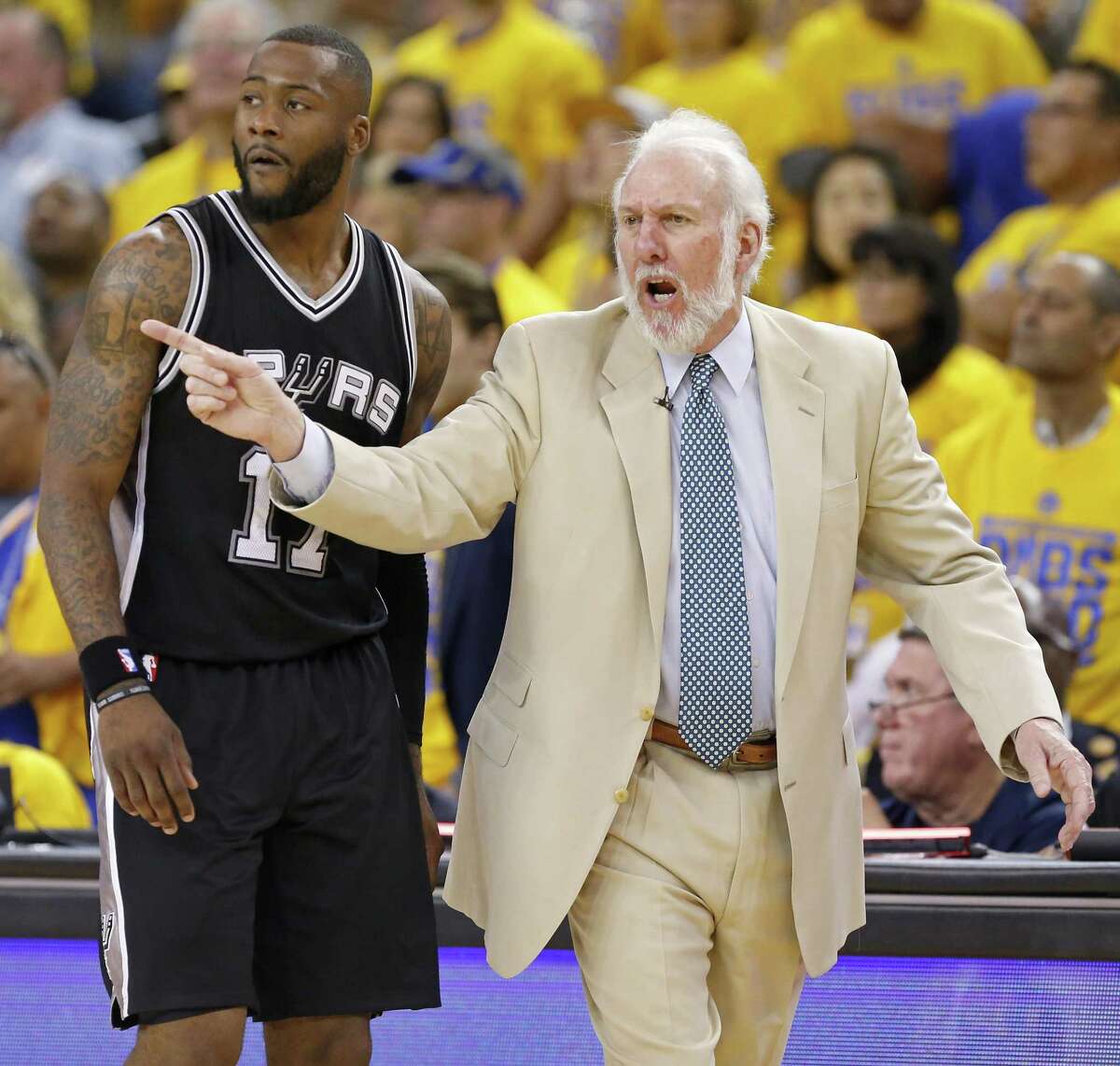 Spurs coach Gregg Popovich calls a play as Jonathon Simmons looks on during second half action of Game 1 in the Western Conference finals against the Golden State Warriors on May 14, 2017 at Oracle Arena in Oakland, Calif.