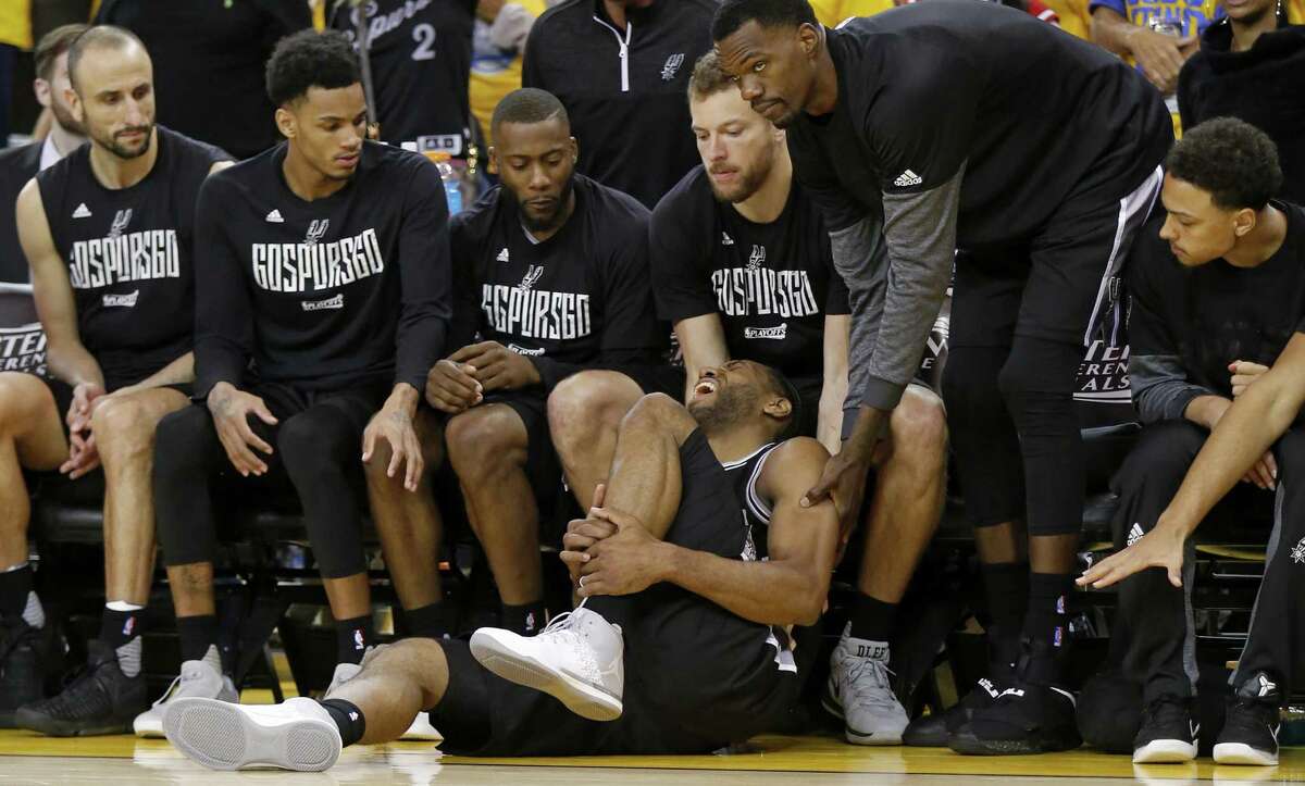 San Antonio Spurs' Kawhi Leonard reacts after being injured on a play as teammates Manu Ginobili (from left), Dejounte Murray, Jonathon Simmons, David Lee, and Dewayne Dedmon and Bryn Forbes look on during second half action of Game 1 in the Western Conference Finals against the Golden State Warriors held Sunday May 14, 2017 at Oracle Arena in Oakland, CA. The Warriors won 113-111.