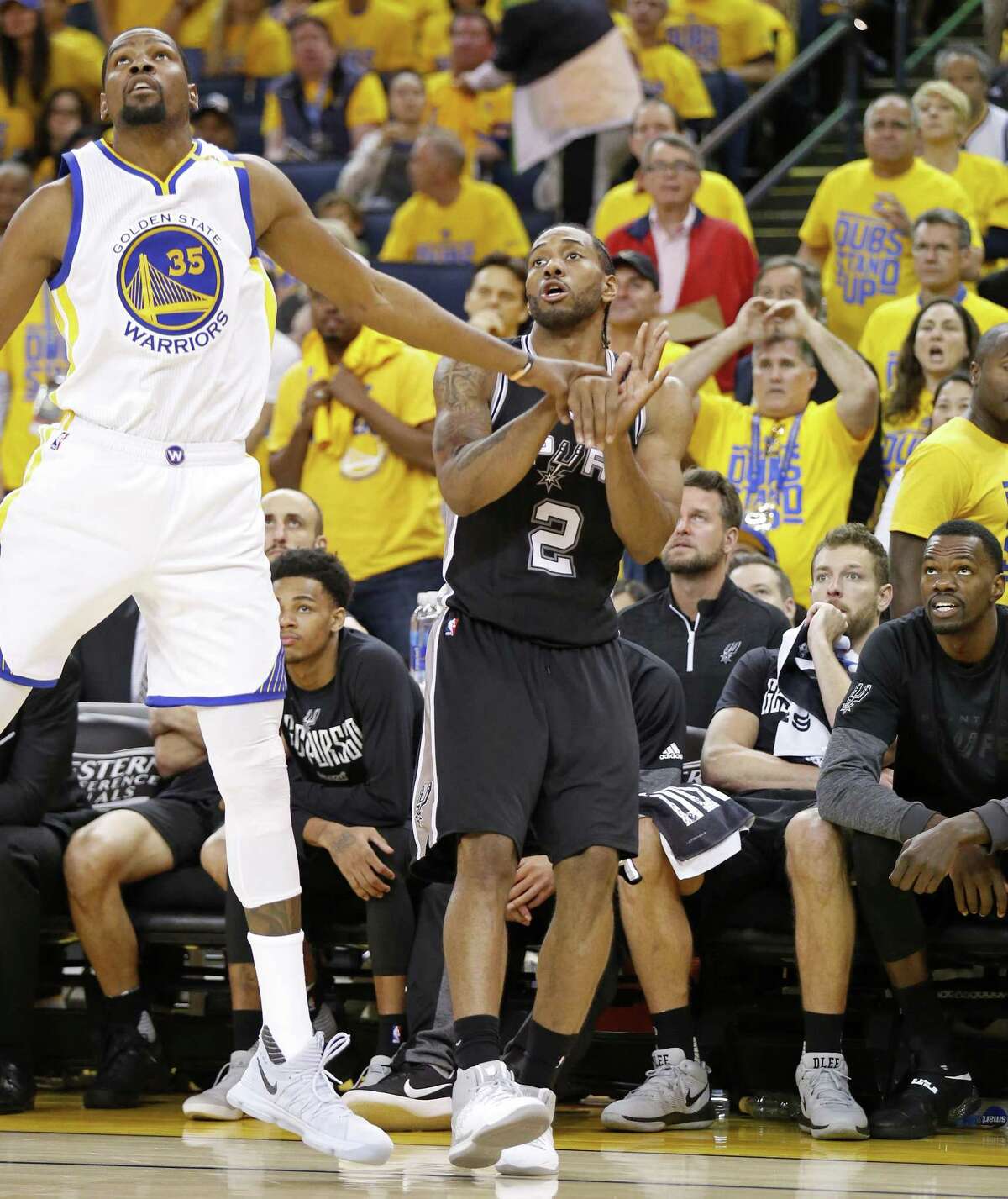 Golden State’s Kevin Durant and the Spurs’ Kawhi Leonard watch Leonard’s shot during second half action of Game 1 in the Western Conference finals against the Warriors on May 14, 2017 at Oracle Arena in Oakland, Calif. Leonard tweaked his left ankle on a teammate’s foot after the play.