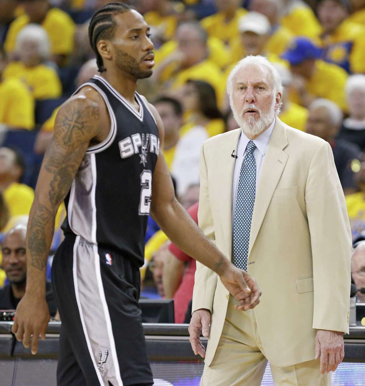 Spurs’ Kawhi Leonard walks to the bench past head coach Gregg Popovich during second half action of Game 1 in the Western Conference fFinals against the Golden State Warriors on May 14, 2017 at Oracle Arena in Oakland, Calif.