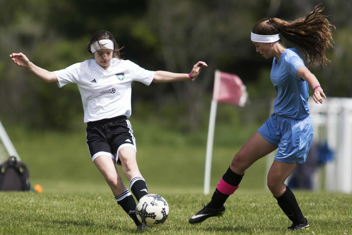 Midland Fusion's Brianna St.Dennis controls the ball while being defended by SCS United's Sophia LaPinta during the Annual Midland Invitational Tournament at the Midland Soccer Complex on Sunday.