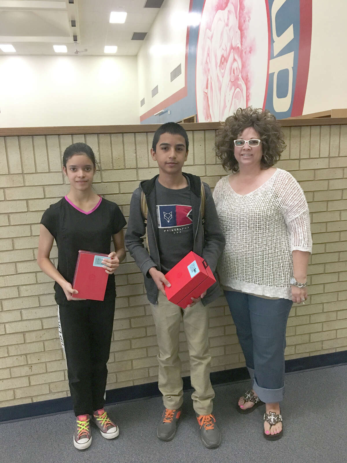 Nathalie Jaime and Juan Garcia Gamboa were perfect attendance award winners for the fifth and sixth six-weeks grading periods at Coronado Middle School. Presenting their prizes is Leigh Ann Bradley, representing Plainview Rotary which sponsors the contest.