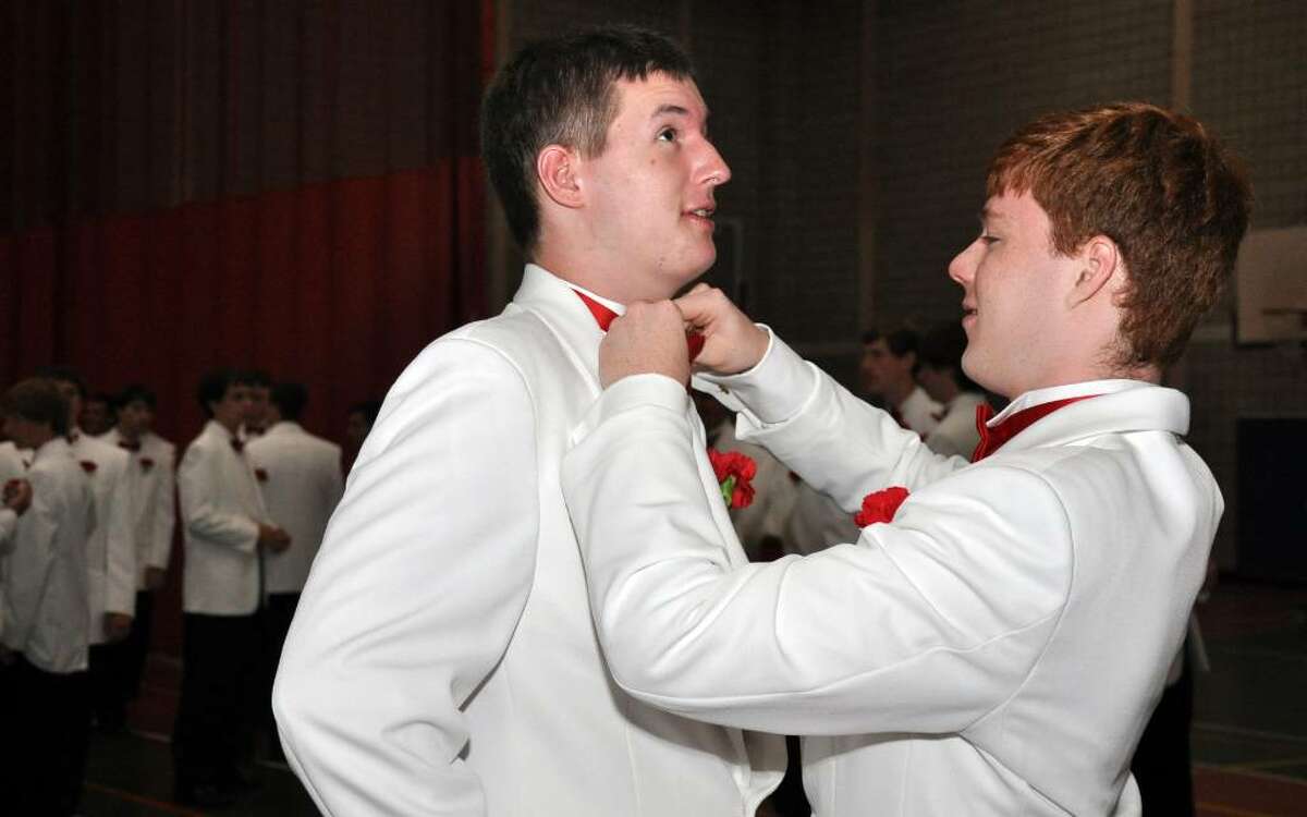 Dan O'Rourke, of Newtown helps classmate Quinn Rooney, of Stratford, with his bow tie in the staging area before the start of Fairfield College Preparatory School's 68th Commencement ceremony on Sunday, June 6, 2010.