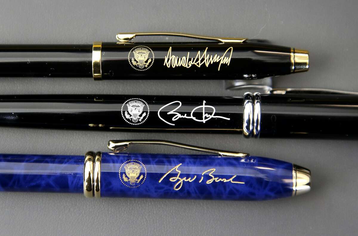 In this Tuesday, Feb. 14, 2017, photo A.T. Cross Co. custom-made pens designed for President Donald Trump, top, former President Barack Obama, center, and former President George W. Bush, below, featuring their signatures and presidential seals, rest side by side at the Cross Company Store in Providence, R.I. (AP Photo/Steven Senne)