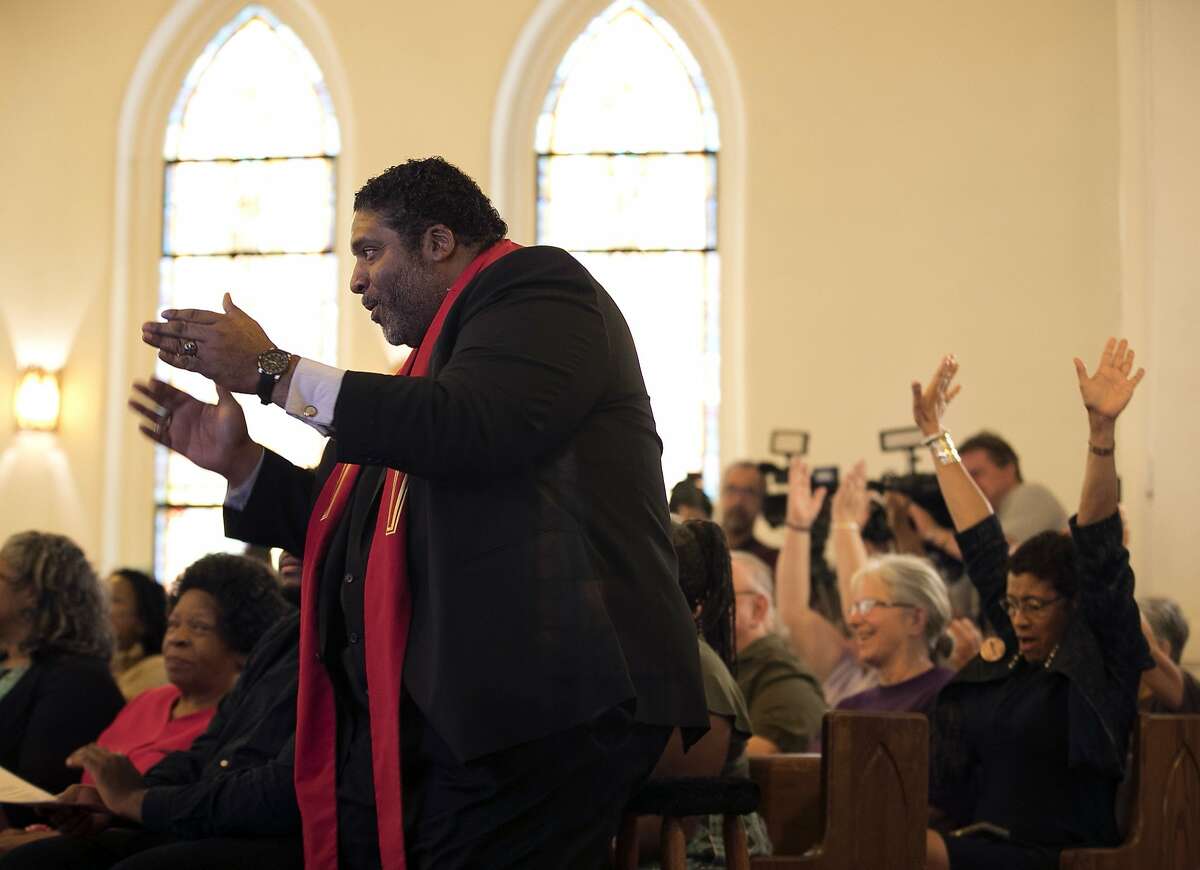 North Carolina NAACP president Rev. William J. Barber II reacts to an announcement Monday, May 15, 2017, by attorney Caitlin Swain, that the US Supreme Court declined to consider reinstating North Carolina's 2013 elections law that included voter ID and other restrictions on voting during a gathering at Davie Street Presbyterian Church in Raleigh, N.C., where Barber announced he is stepping down as NAACP president. (Robert Willett /The News & Observer via AP)