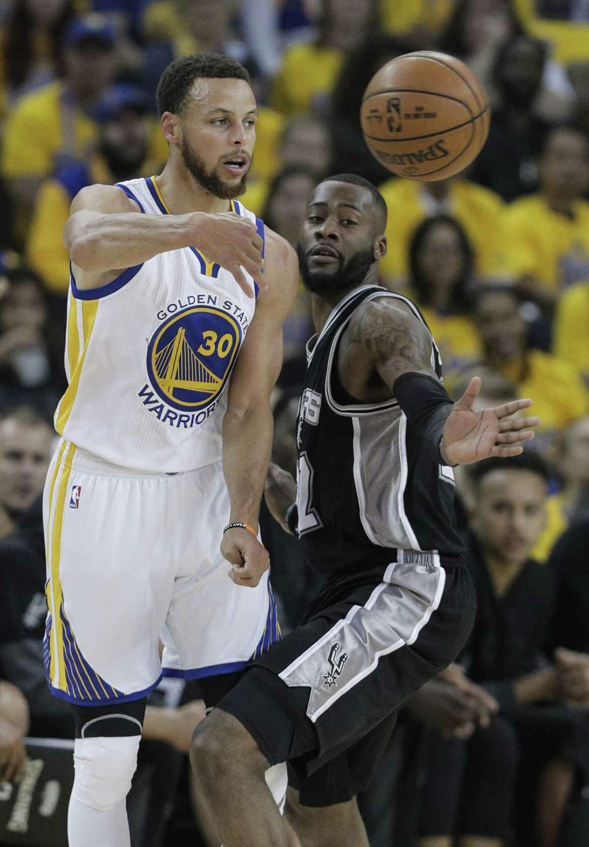 Golden State Warriors’ Stephen Curry passes around the Spurs’ Jonathon Simmons in the first quarter during Game 1 of the Western Conference finals at Oracle Arena on May 14, 2017 in Oakland, Calif.