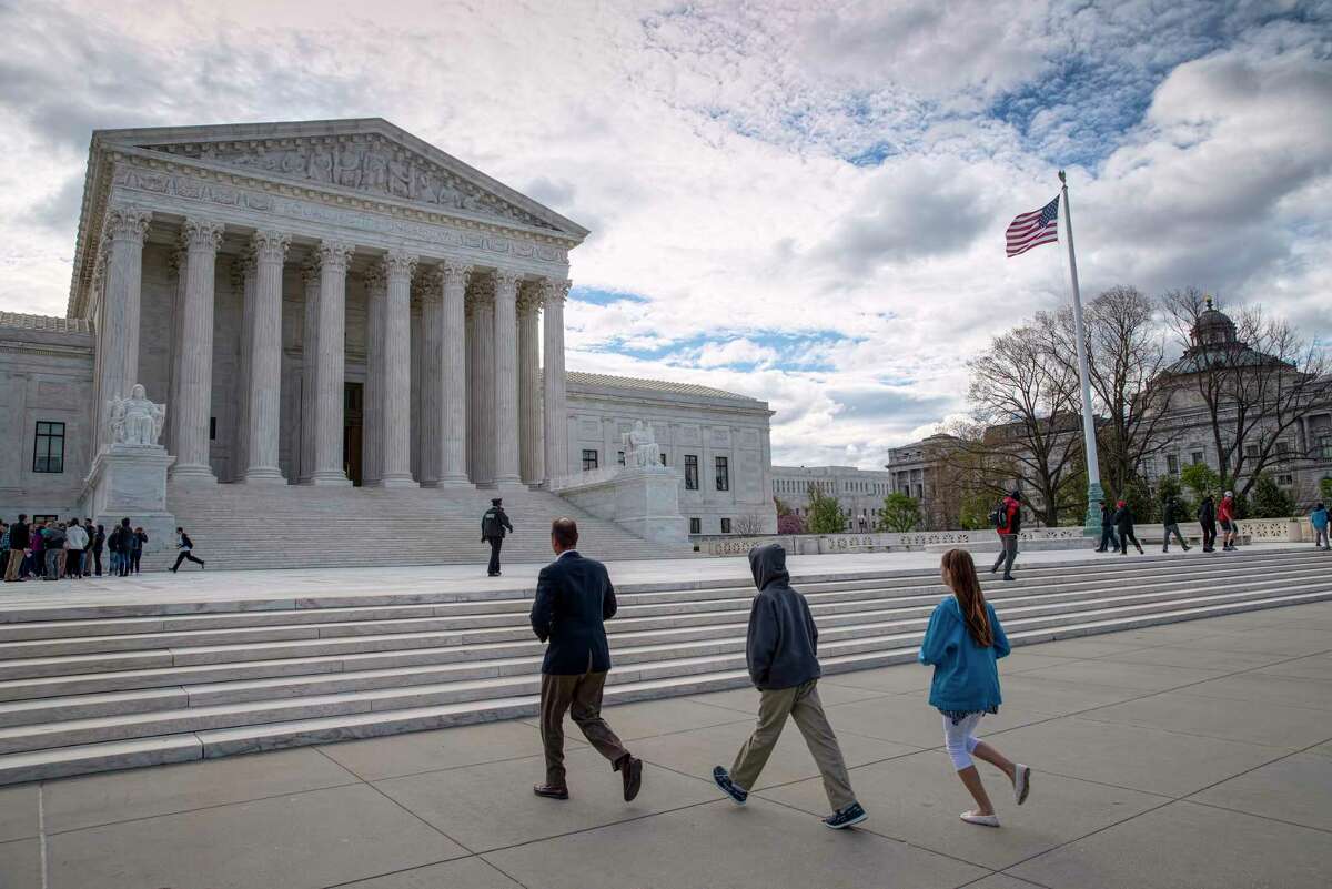 FILE - In this April 7, 2017 file photo, visitors arrive at the Supreme Court in Washington. The Supreme Court on Monday, May 15, 2017, rejected an appeal to reinstate North Carolina's voter identification law that a lower court said targeted African-Americans "with almost surgical precision." (AP Photo/J. Scott Applewhite, File)