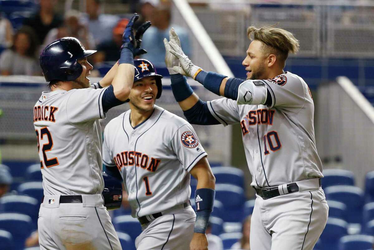Houston Astros' Yuli Gurriel (10) is congratulated by Josh Reddick (22) and Carlos Correa (1) after Gurriel hit a grand slam scoring Reddick, Correa and Evan Gattis during the sixth inning of a baseball game against the Miami Marlins, Monday, May 15, 2017, in Miami. (AP Photo/Wilfredo Lee)