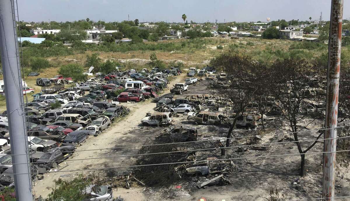 Vehicles, many burned and destroyed in ongoing battles between drug cartels fighting for dominance in Reynosa, Mexico, sit in a lot. Clashes there since late April have left 28 people dead.