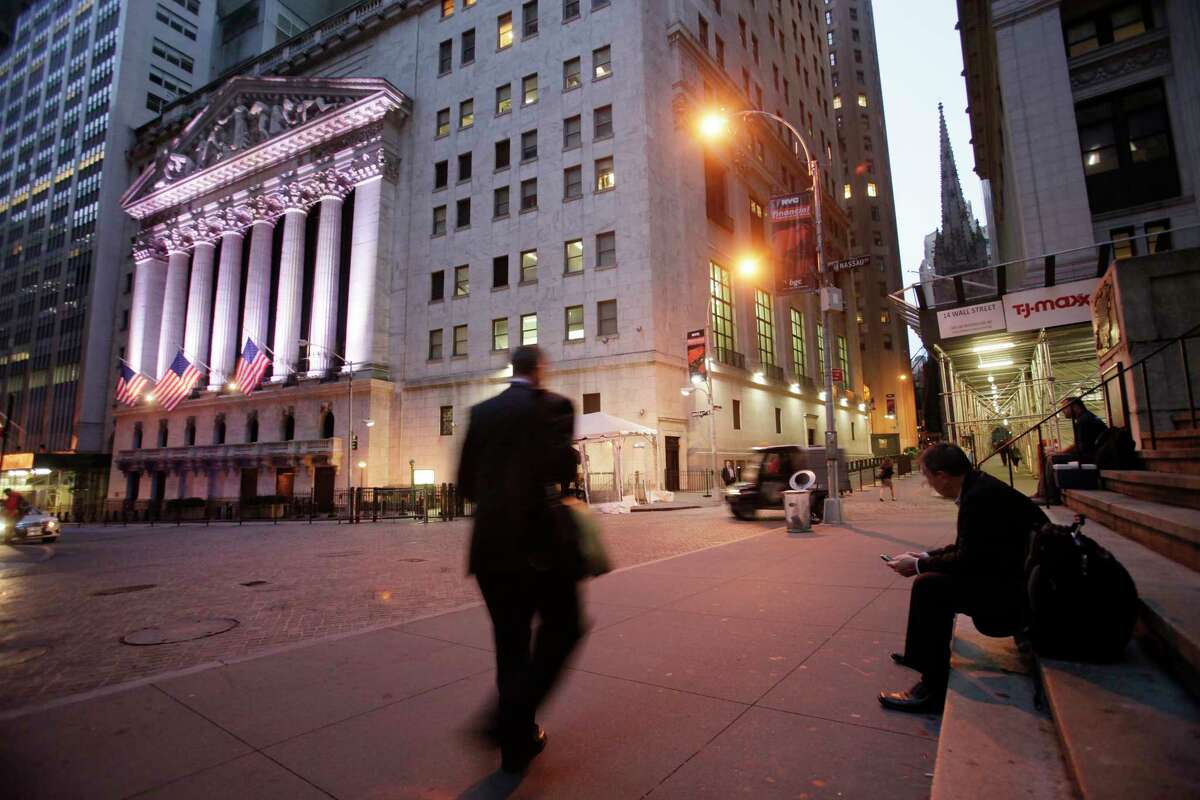 FILE - In this Oct. 8, 2014, file photo, a man walks to work on Wall Street, near the New York Stock Exchange, in New York. Shares edged higher Monday, May 15, 2017, in Europe and Asia, despite worries of disruptions from the "WannaCry" ransomware cyberattack over the weekend. (AP Photo/Mark Lennihan, File)