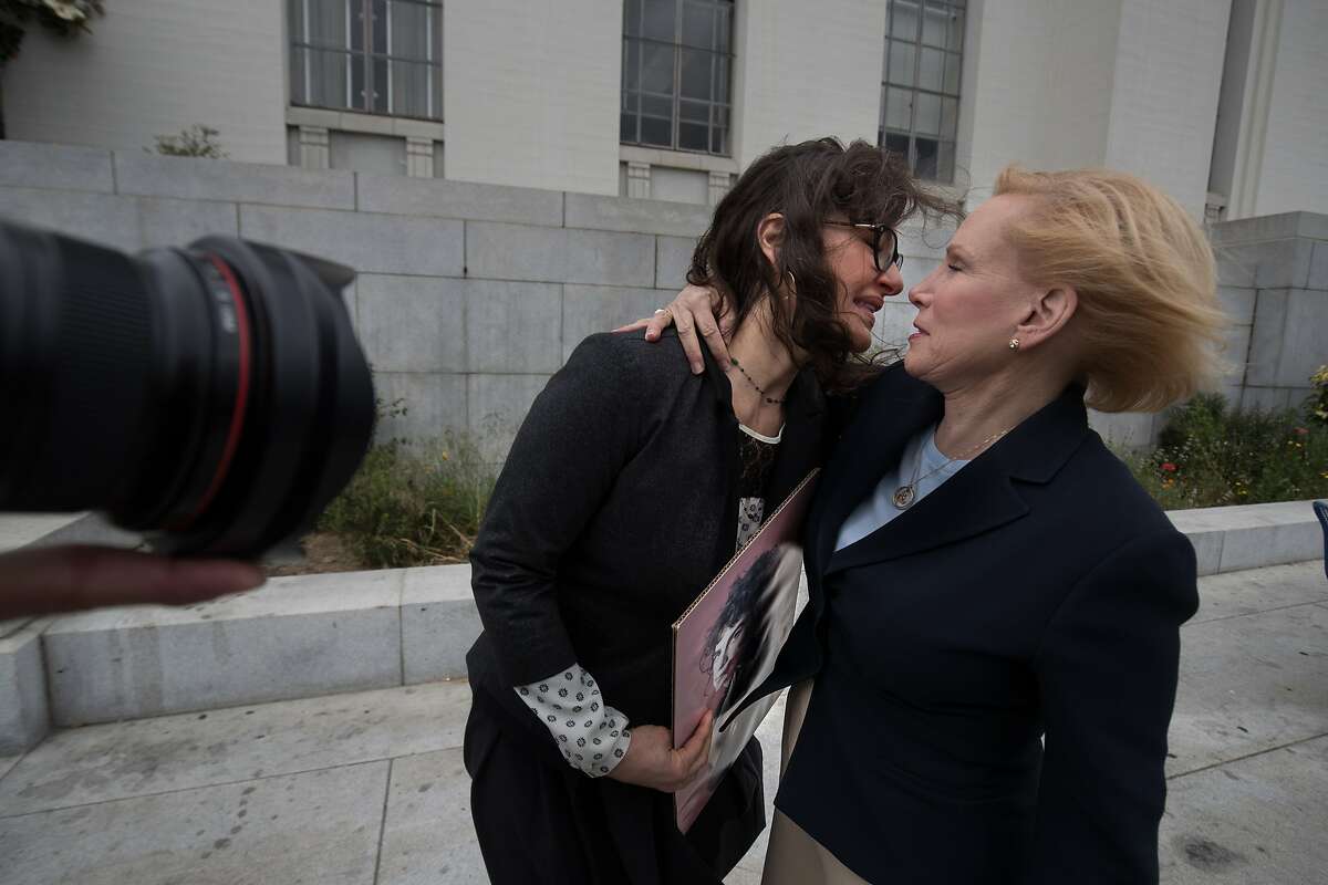Leisa Askew holds a photo of her daughter Cash, 22, who died in the Ghostship fire is hugged by attorney Mary Alexander after a press conference on Tuesday, May 16, 2017 in Oakland, Calif. at the Alameda County Courthouse.
