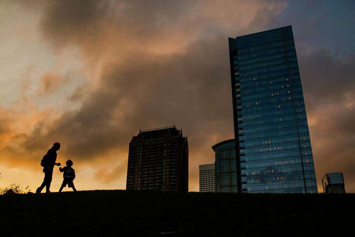 Angel Chavez and his 3-year-old son, Kaivon, play on a hill at Discovery Green as the sun sets.