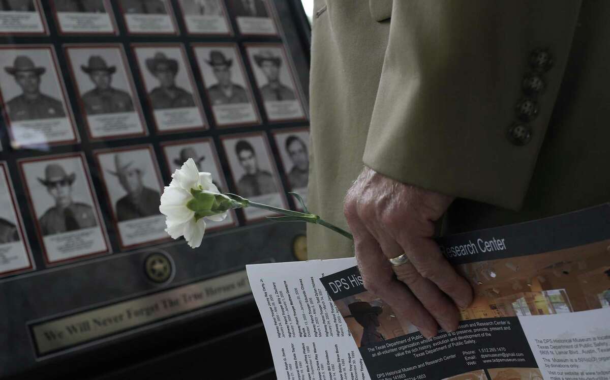 Charles Cooper holds a carnation while looking at photographs during the Texas Department of Public Safety Memorial Service in Austin, Tuesday, May 16, 2017. The service honored troopers and Texas Rangers who died in the line of duty. Cooper?’s father, Sgt. Gara Oliver Cooper, was killed when struck by a vehicle while directing traffic on Oct. 2, 1970.