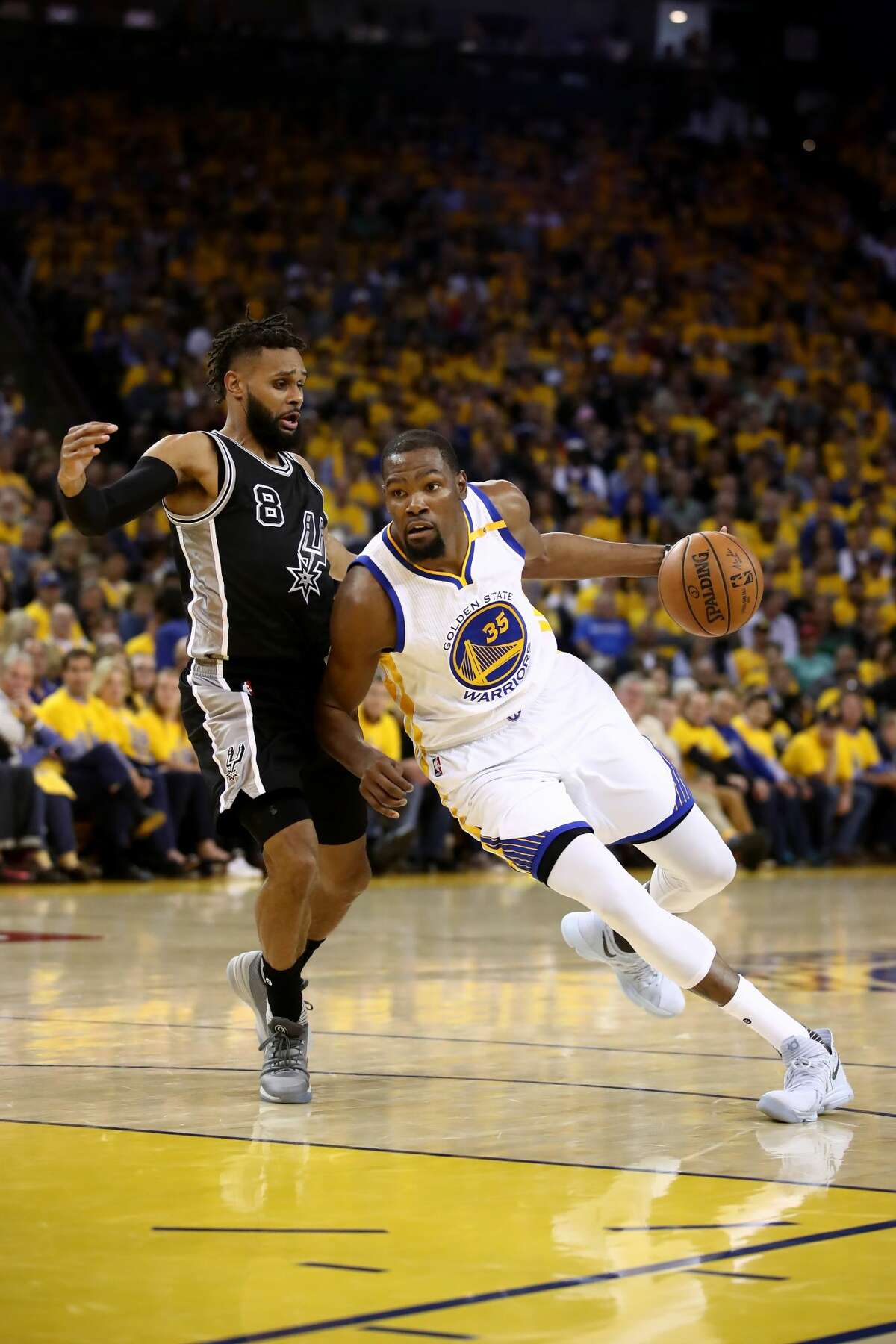 OAKLAND, CA - MAY 16: Kevin Durant #35 of the Golden State Warriors drives with the ball against Patty Mills #8 of the San Antonio Spurs during Game Two of the NBA Western Conference Finals at ORACLE Arena on May 16, 2017 in Oakland, California. NOTE TO USER: User expressly acknowledges and agrees that, by downloading and or using this photograph, User is consenting to the terms and conditions of the Getty Images License Agreement. (Photo by Ezra Shaw/Getty Images)