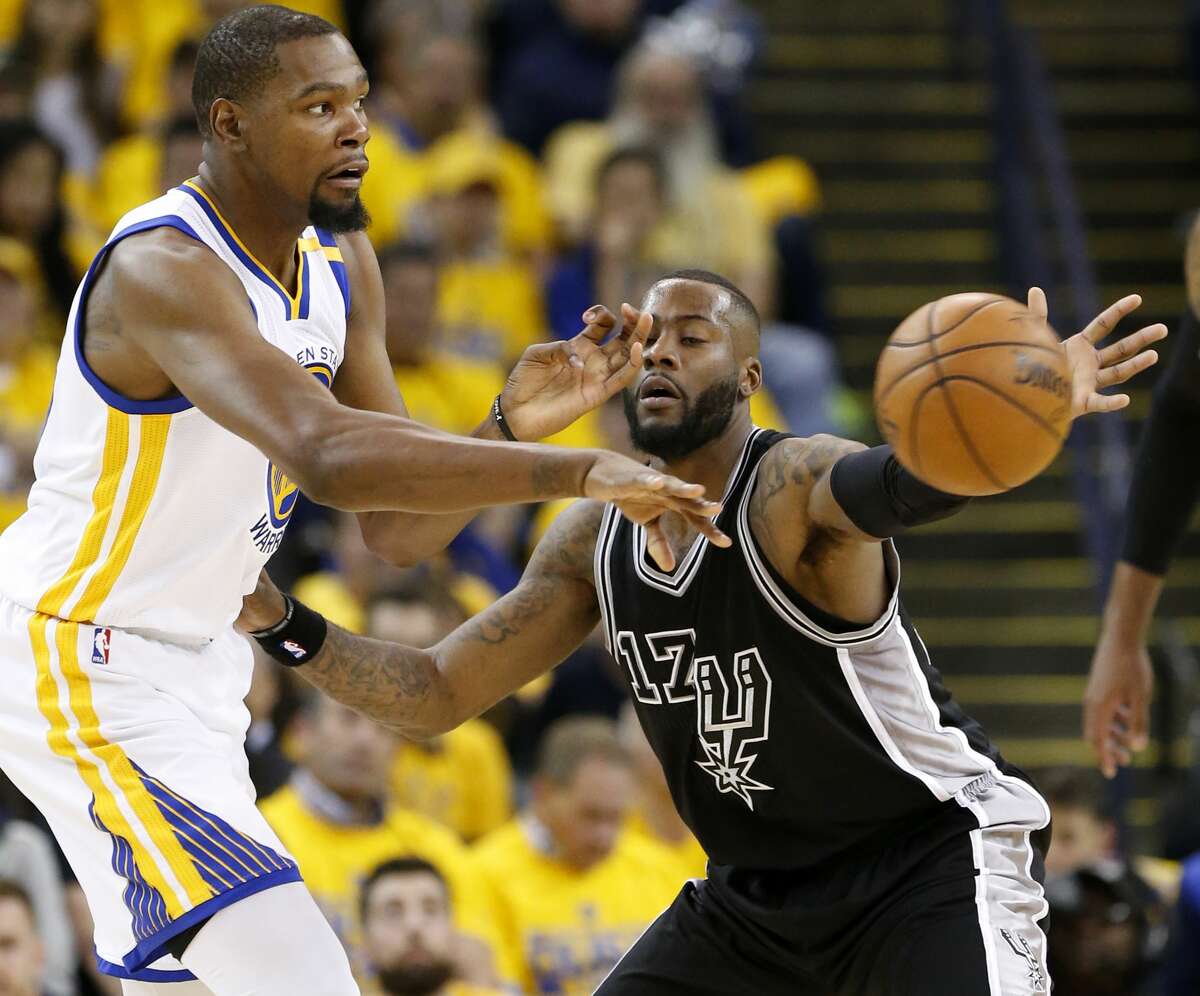 Golden State Warriors' Kevin Durant passes around San Antonio Spurs' Jonathon Simmons during first half action in Game 2 of the Western Conference Finals held Tuesday May 16, 2017 at Oracle Arena in Oakland, CA.