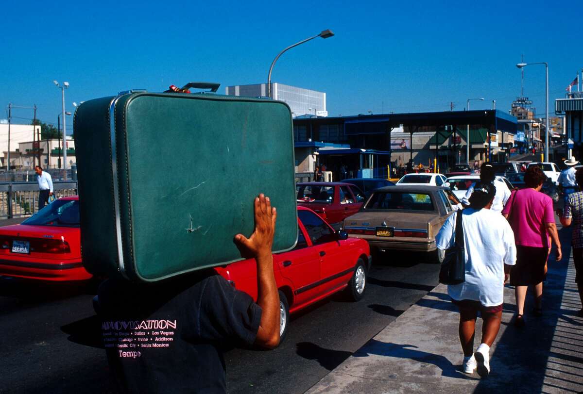 A Mexican man carries his suitcase on his shoulders September 15, 1991 at a border crossing in Nuevo Laredo, Mexico into Laredo, Texas.
