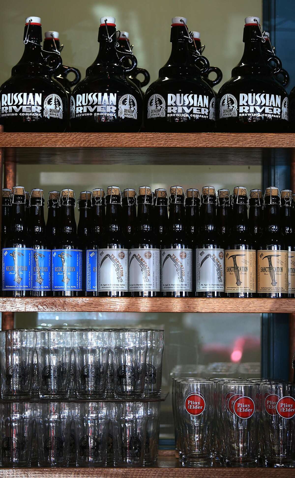 Bottles of beer, glasses, and growlers displayed at the Russian River Brewing Company brewpub in Santa Rosa, Calif., on Monday, October 26, 2015.