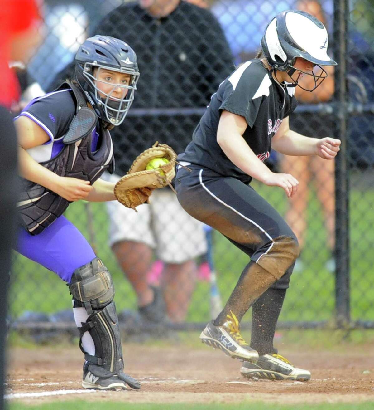 New Canaan Rachel Keshin slides past the tag of Westhill Jordan Benzaken in a varsity girls softball game at Waveny Park in New Canaan on May 16, 2017. Westhill won 3-2.