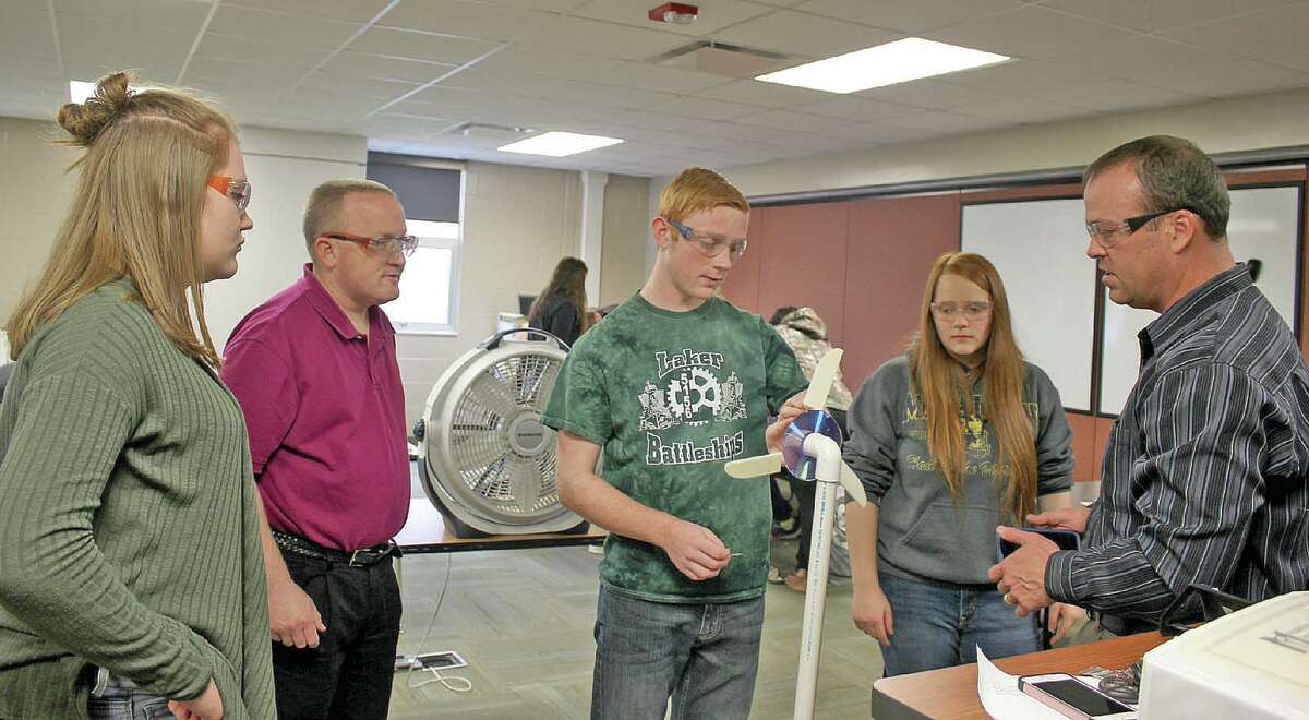   From the left, Kennedy Bouck, science teacher Scott Lebsack, Aaron Baranski and Kylie Chubb work with Nathan Elder, of Delta College, to test the student team’s turbine blades they designed using a computer-aided design (CAD) program called Solid Works.