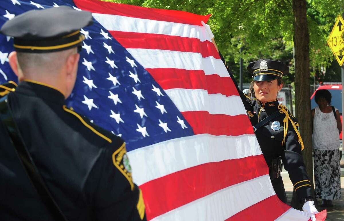 Norwalk police Sergeant Joseph Moquin and Officer Cristina Capela retire the flag as dignitaries, and other local police departments take part in the annual police memorial at police headquarters in honor of National Police Week Wednesday, May 17, 2017, in Norwalk, Conn.