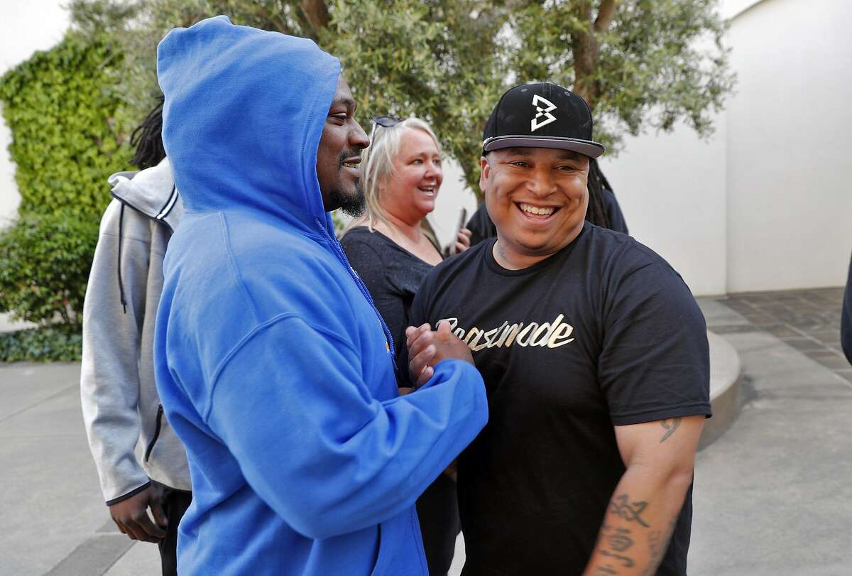 Marshawn Lynch, left, greets producer Diaunte Thompson, right, as Lynch arrives to the premier of the movie 100 Blocks at The Letterman Digital Arts Center in San Francisco, Calif., on Wednesday, May 17, 2017.