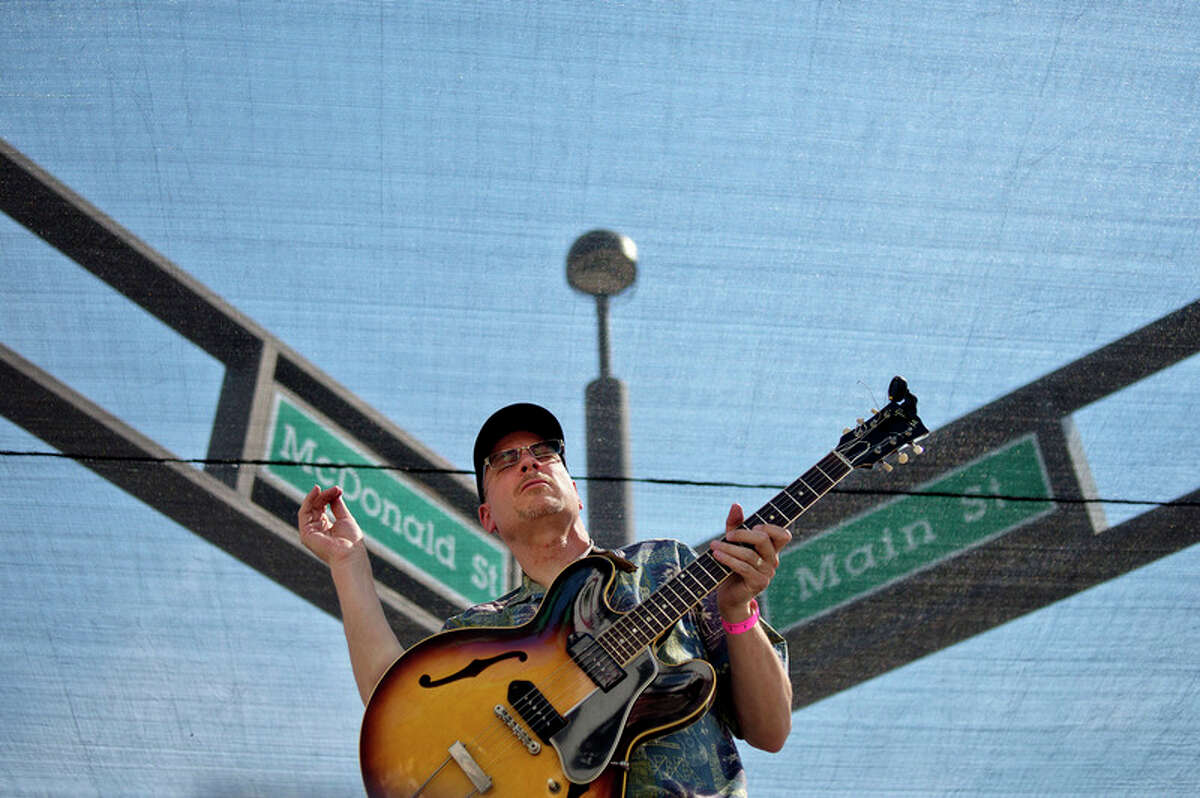 The Straight Eights band member Scott Van Dell finishes a guitar solo on stage under the signs for McDonald and Main streets during 2016's Tapped.