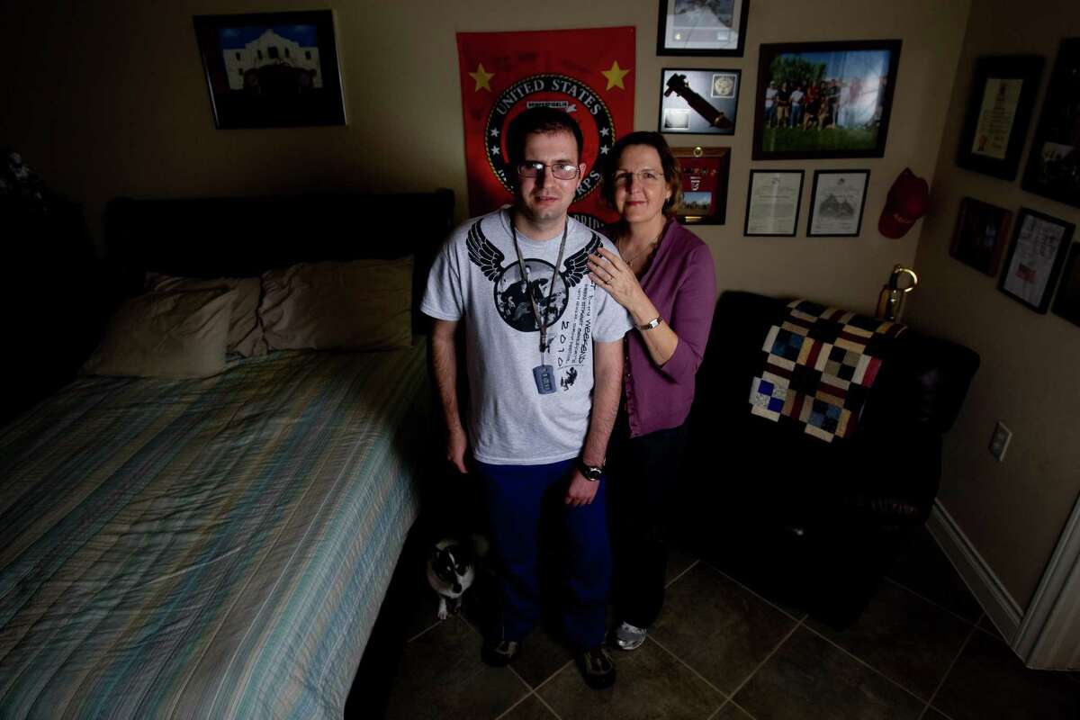 Twenty-six year-old retired Marine Cpl. Steven Schulz stands next to his mother Debbie Schulz at their Friendswood home, Thursday February 25, 2011. Schulz an Iraq war veteran from Friendswood who suffered traumatic brain injury in April 2005 when an improvised explosive devise sent shrapnel through his eye into his main cerebral artery, leaving him paralyzed on his left side and blind in one eye. Congress passed legislation in May to provide health care, mental health services, training and stipends to relatives who have become full-time caretakers to veterans of the wars in Iraq and Afghanistan. The law was supposed to help people like Debbie Schulz, who quit her job as a teacher to take care of her son, Steven, 26, an Iraq war veteran from Friendswood. The deadline for the legislation to go into effect passed in January. But red tape has delayed the promised benefits. Nine months after President Obama authorized a broad expansion of the benefits, no one can yet apply, no funding has been allocated and new regulations threaten to reduce the number of families eligible for help. (Billy Smith II / Houston Chronicle)