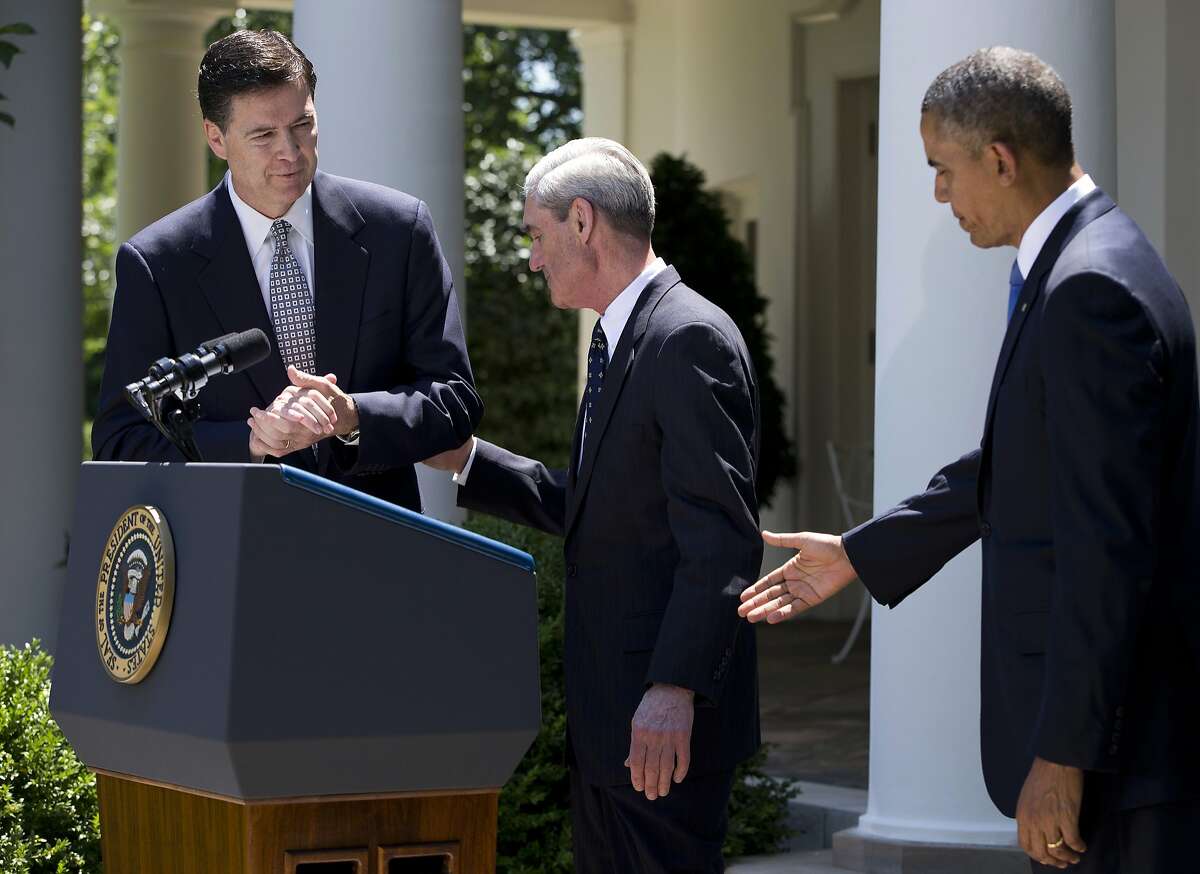 FILE - In this June 21, 2013, file photo, James Comey, left, a senior Justice Department official under President George W. Bush, is invited by President Barack Obama, right, to speak in the Rose Garden of the White House in Washington, after the president announced he would nominate Comey to replace Robert Mueller, center, as FBI director. The Justice Department appointed former FBI Director Robert Mueller May 17, 2017, as a special counsel to oversee the federal investigation into allegations that Russia and Donald Trump's campaign collaborated to influence the 2016 presidential election, giving Mueller sweeping powers and the authority to prosecute any crimes uncovered in the probe. (AP Photo/Evan Vucci, File)