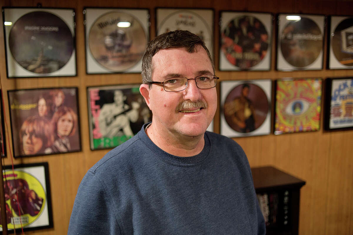 BRITTNEY LOHMILLER | blohmiller@mdn.net Bill Young of Midland poses for a portrait amongst his picture disc records Monday afternoon. Young is the administrator for the Michigan Record Club's Facebook page, which is a page for record collectors and enthusiasts. Young has approximately 2,400 records in his collection. 'I've always had records in my life,' Young said. 'But it wasn't until my second marriage that I started going to shops and collecting records.'