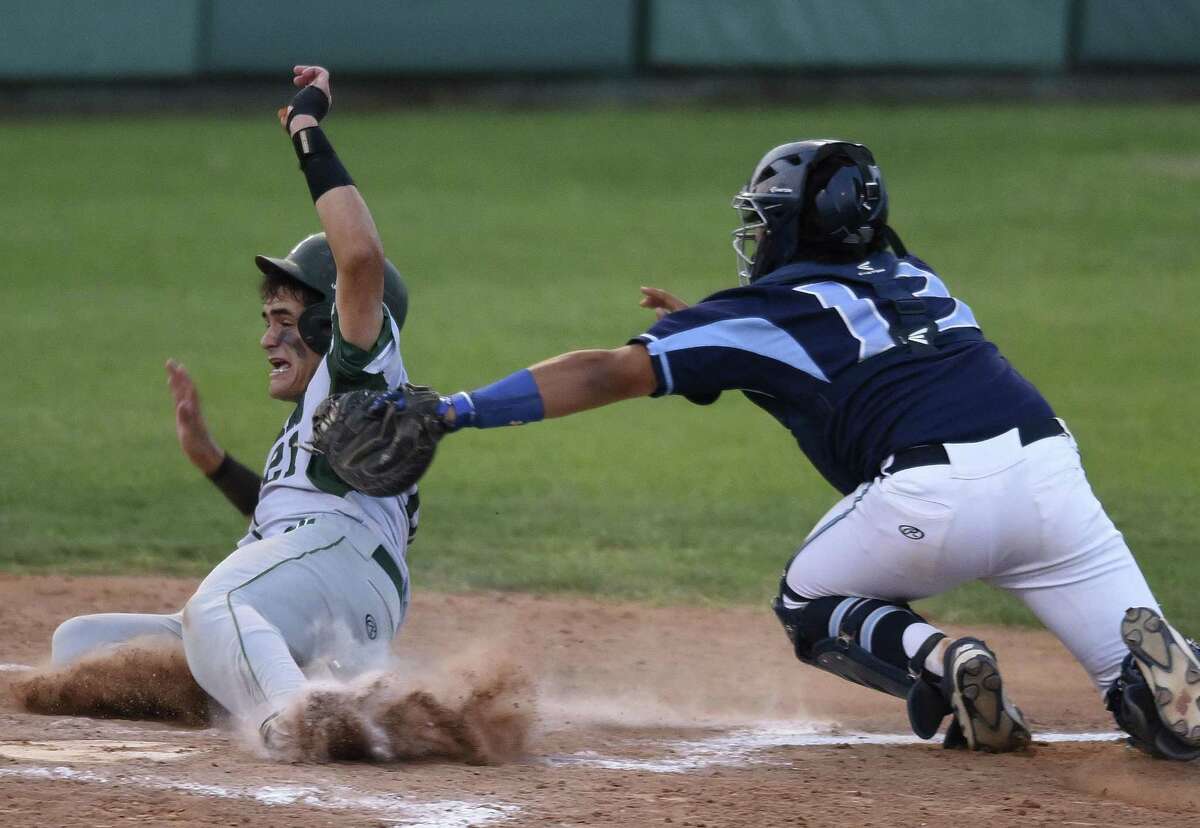Ramon Garza of Reagan is tagged out by Johnson catcher Dominic Tamez during Game 1 of their Class 6A third-round playoff series on May 18, 2017.