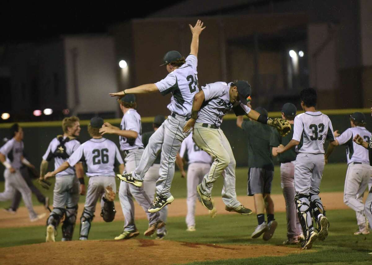 Reagan starting pitcher Jake Hoggatt (24) and shortstop Ramon Garza celebrate after defeating Johnson 7-2 in Game 1 of the Class 6A third-round playoff series on May 18, 2017.