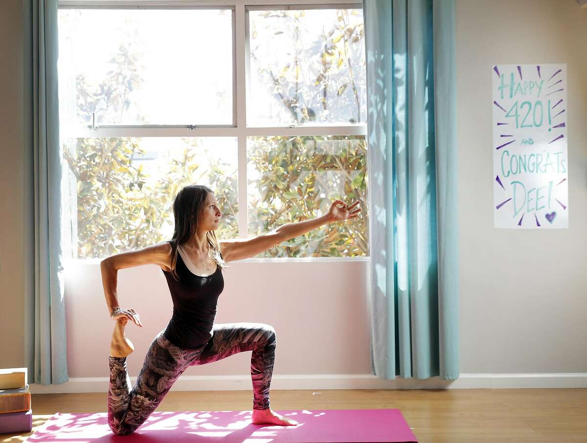 Dee Dassault, creator of Ganja Yoga, demonstrates a yoga pose in a studio she uses for her classes in San Francisco, Calif., on Thursday, May 18, 2017.