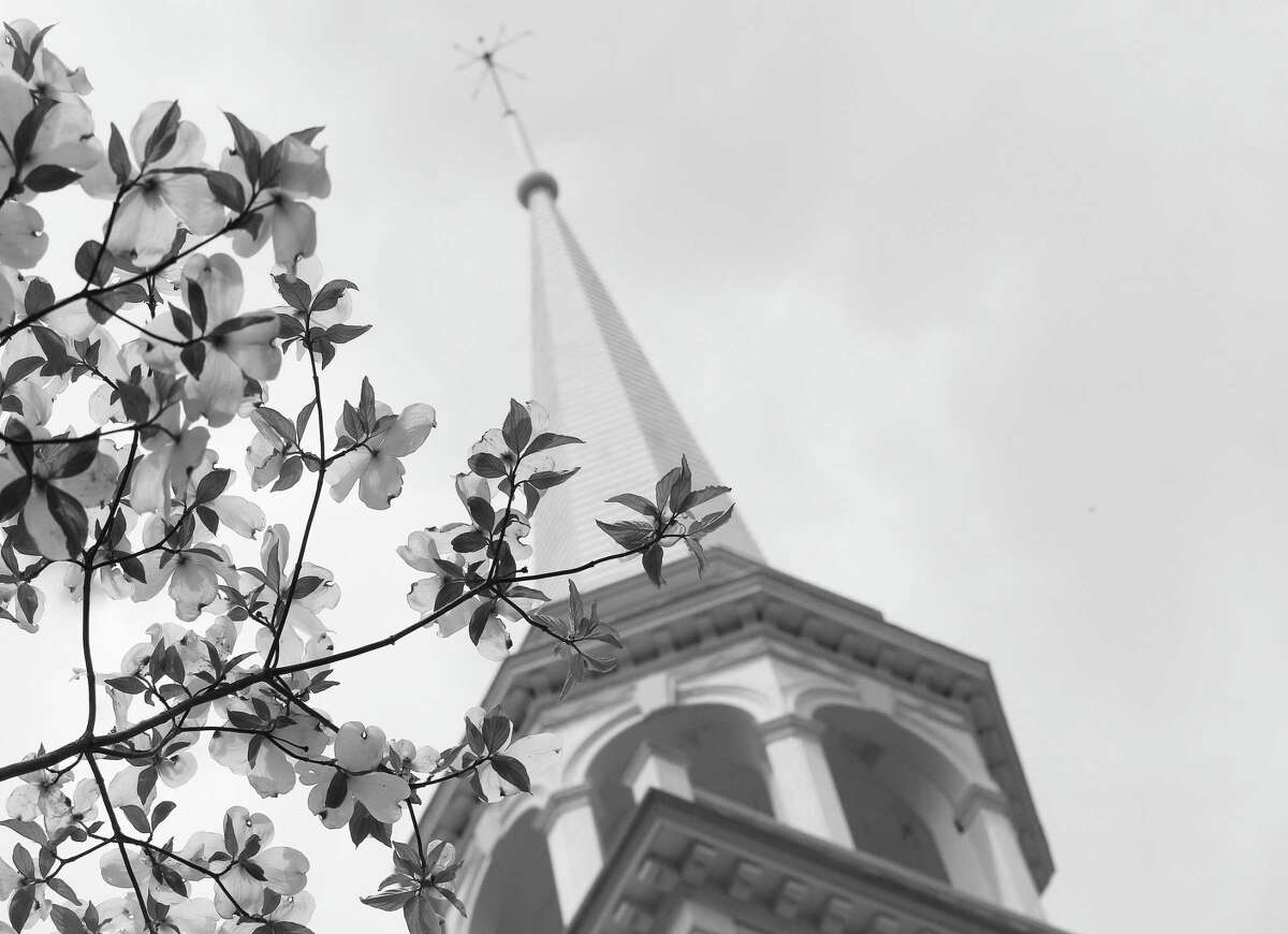 Greenfield Hill Congregational Church towers above flowering trees on a warm spring day in Fairfield.