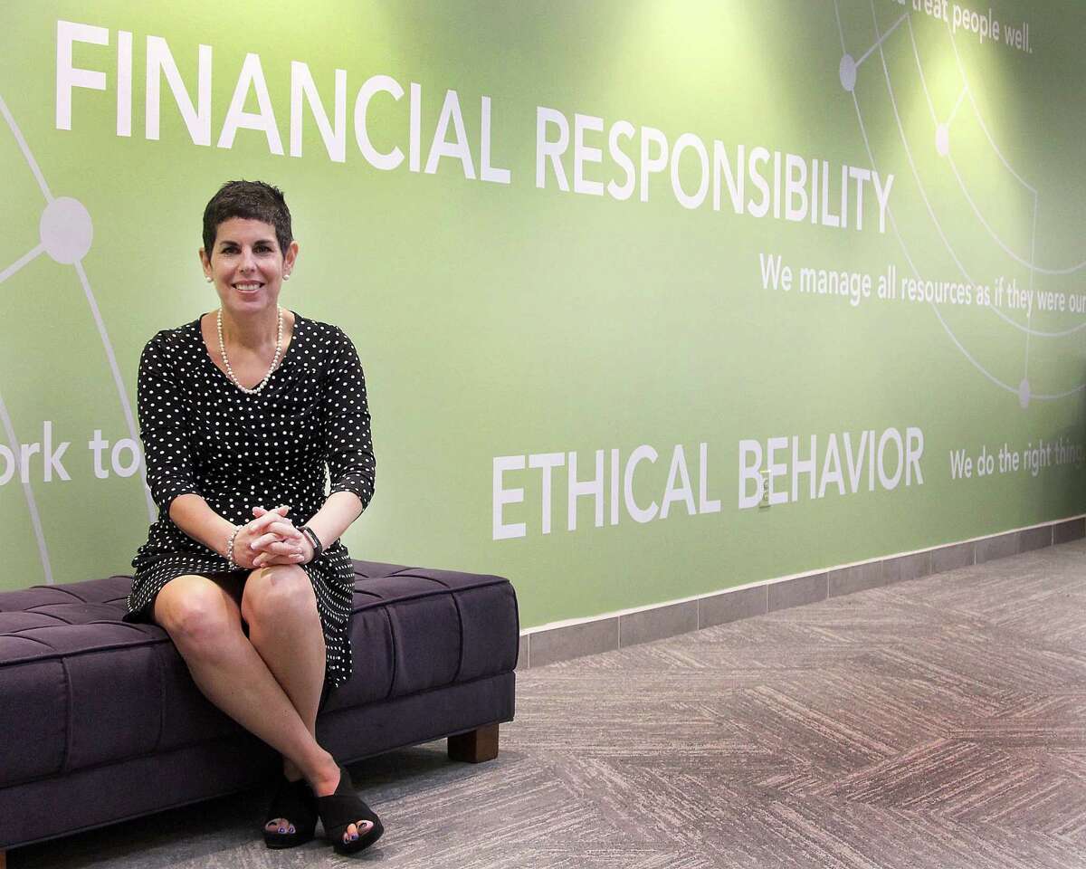 Amy Meichner, senior vice president of human resources, sits near a wall that highlights Cartus's values at the company's headquarters in Danbury, Conn., on Tuesday, May 16, 2017.