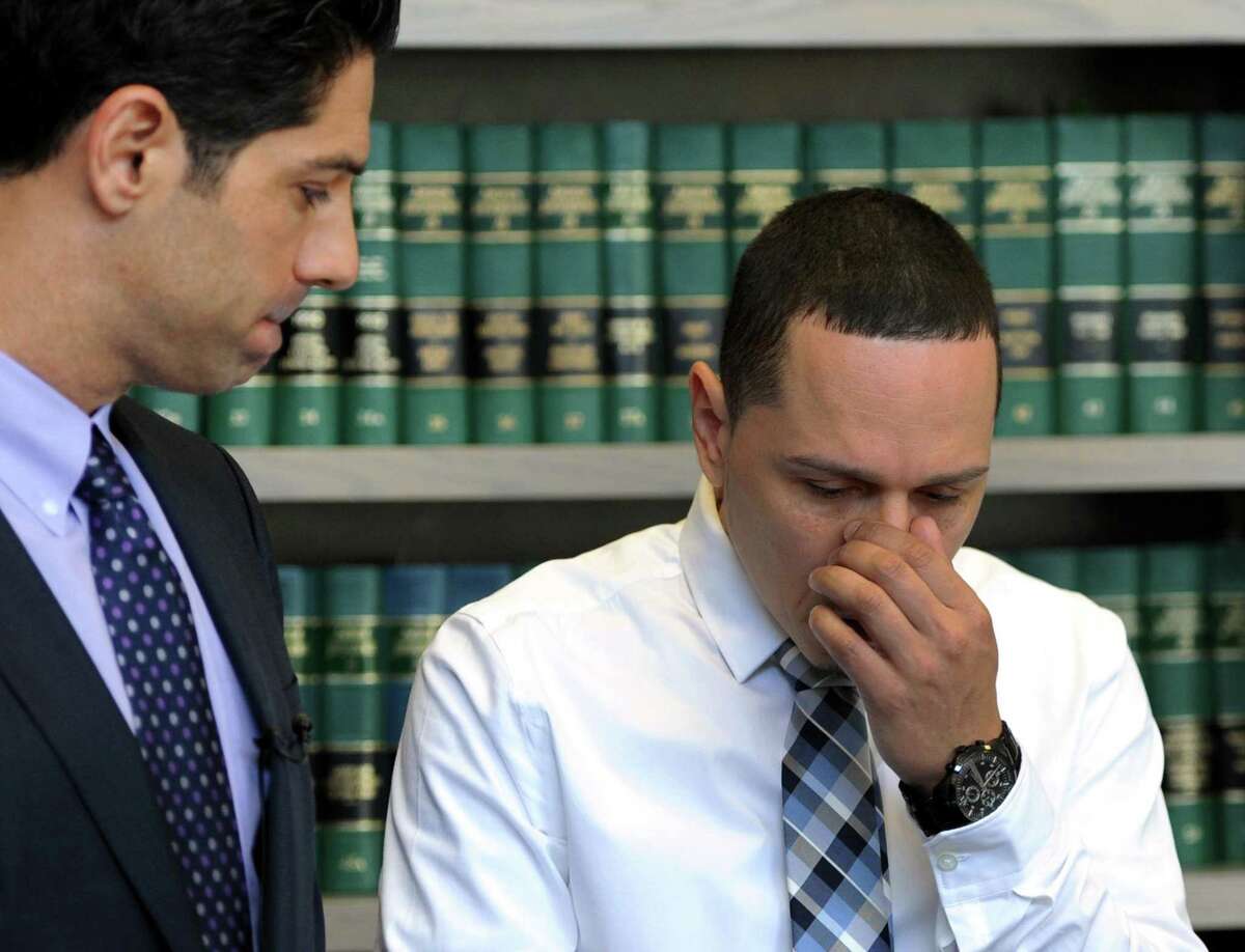 Juan Negron, right, father of Jayson Negron, listens as his lawyer, Michael Rosnick makes a statement to the press in the law office on Broad Street in Bridgeport, Conn. on Friday, May 19, 2017. "It appears that the vehicle was not stolen, there was never a police chase and no officer's life was in danger to justify the use of deadly force, on a child nonetheless." said Rosnick.