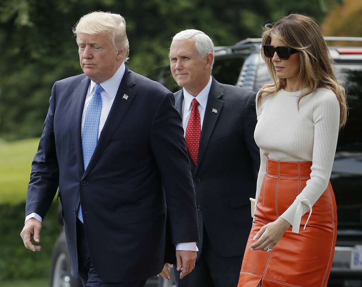 Vice President Mike Pence, center, watches as President Donald Trump and first lady Melania Trump walks across the South Lawn of the White House in Washington, Friday, May 19, 2017, before the president and first lady boarded Marine One for a short trip to Andrews Air Force Base, Md. (AP Photo/Pablo Martinez Monsivais)