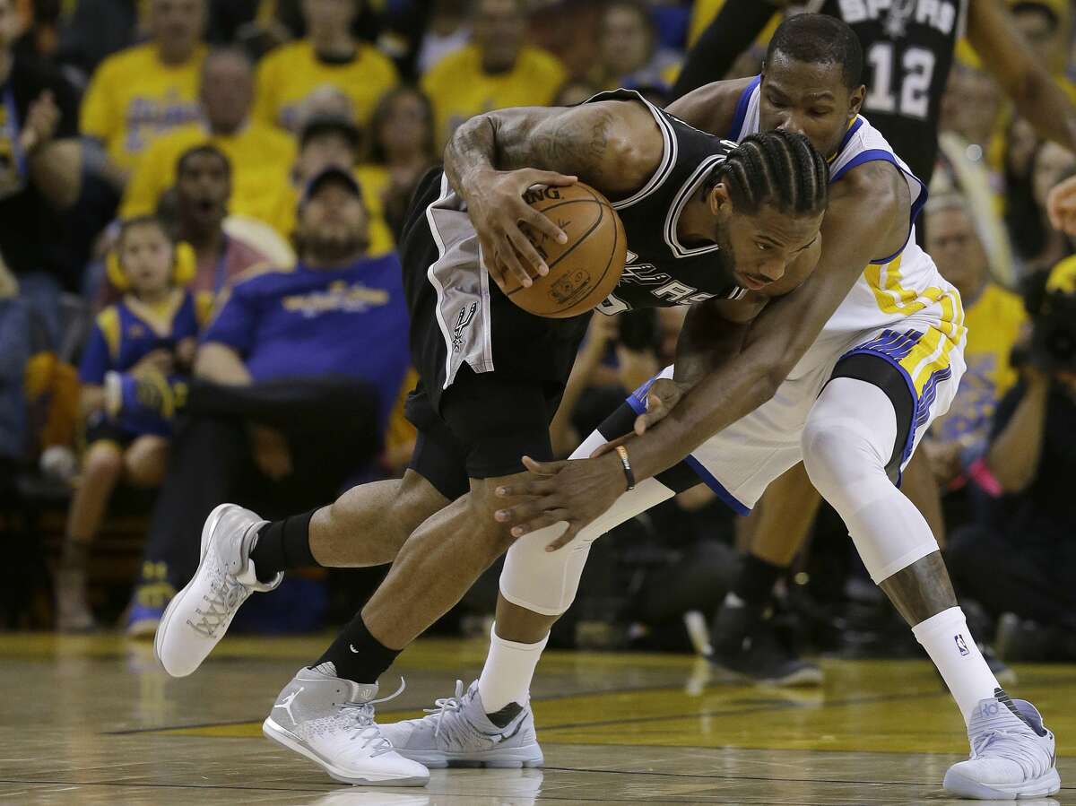 San Antonio Spurs forward Kawhi Leonard, left, dribbles against Golden State Warriors forward Kevin Durant during Game 1 of the NBA basketball Western Conference finals in Oakland, Calif., Sunday, May 14, 2017. (AP Photo/Jeff Chiu)