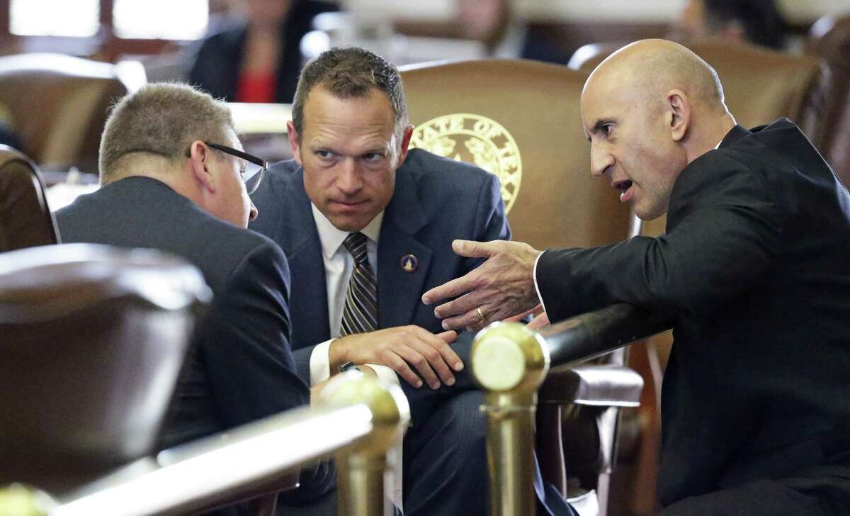Representatives (from left) Tony Dale, R-Cedar Park, Jason Isaac, R-Dripping Springs and Matt Shaheen, R-Plano confer as property tax legislation is considered on the floor of the House at the Texas Capitol on May 18, 2017.